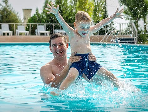 Father playing with son in pool