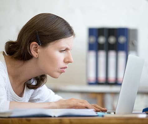 Woman having trouble reading her computer